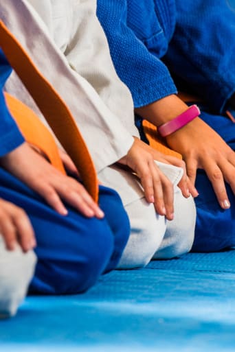 Selbstverteidigung für Kinder: Nahaufnahme von einer Schülergruppe beim Kampfsporttraining.