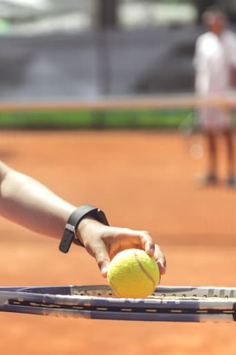 Tenis dla dzieci – chłopiec uczy się serwisu w szkółce tenisowej.
