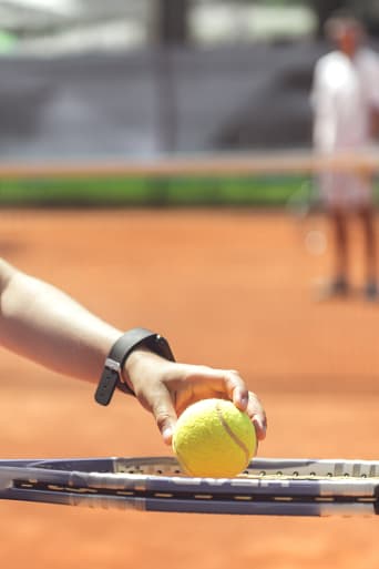 Tennis voor kinderen: jongen oefent zijn opslag tijdens een tennistraining.