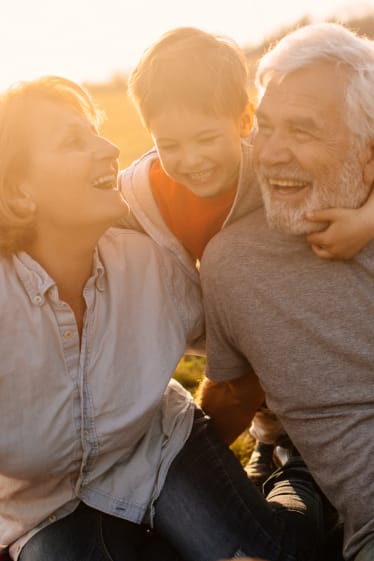 Activité à la retraite : des grands-parents rient avec leur petit-fils.