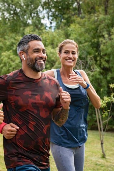 Sportliche Hobbys für Erwachsene – eine Gruppe von Läufern joggt gemeinsam im Park.