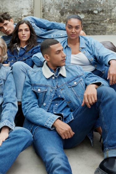 Een groep zittend op een bank in jeans outfits