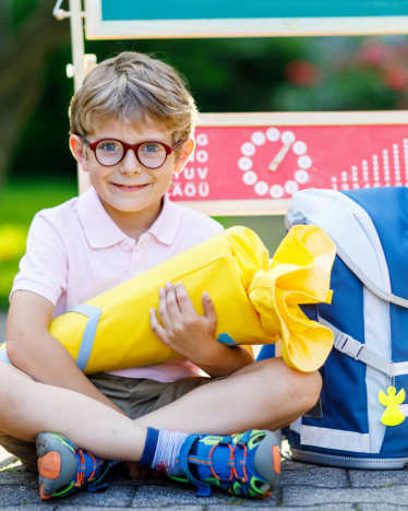 Ratgeber Einschulung – Kleiner Junge mit Schulranzen und Zuckertüte freut sich auf die Schuleinführung. Ratgeber Einschulung – Kleiner Junge mit Schulranzen und Zuckertüte freut sich auf die Schuleinführung.