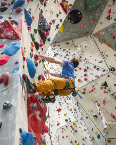 Escalade pour adultes : un homme grimpe sur un mur d’escalade. Escalade pour adultes : un homme grimpe sur un mur d’escalade.