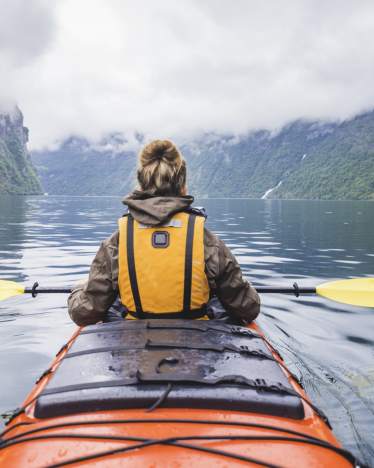 Sports pour adultes : une femme fait du kayak sur un lac. Sports pour adultes : une femme fait du kayak sur un lac.