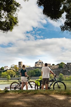 La Loire à vélo : deux cyclistes profitent de la vue sur le château d’Angers lors de leur rando vélo.