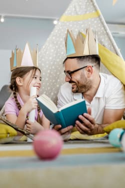 Kinderen voorlezen: Vader leest zijn dochter een sprookjesverhaal voor.