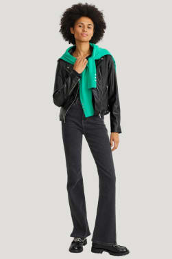 Outfit de viaje: chaqueta motera negra con vaqueros azules.