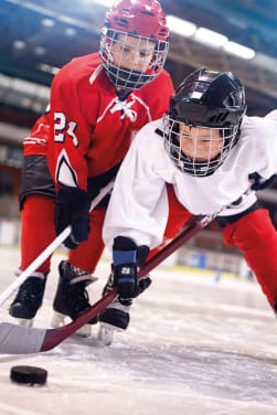 Eishockey Kinder: Zwei Teams spielen gegeneinander Hockey.