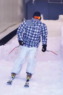 Skihalle: Ein Skifahrer fährt eine Indoor-Skipiste herunter.