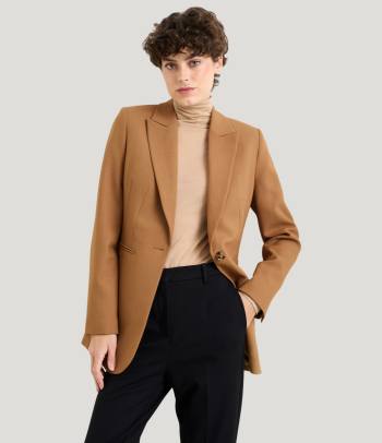Jak se obléct na firemní večírek: Žena ve stylovém smart-casual outfitu.