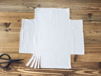 Paasversiering zelf maken: stofresten voor het paaskussen in vierkanten knippen.
