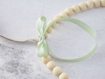 Making a homemade Easter wreath: using a piece of ribbon to cover the piece of wire.
