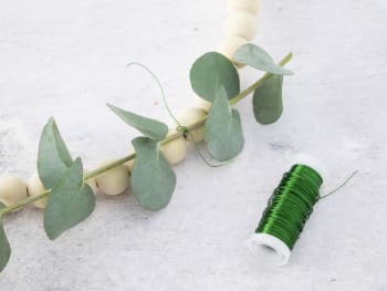 Making homemade Easter decorations out of natural materials: an Easter wreath decorated with some greenery.