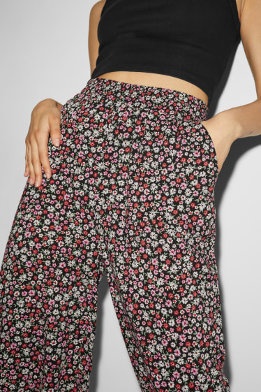 Nastolatki - CLOCKHOUSE - spodnie materiałowe - wysoki stan - szerokie nogawki - w kwiatki - kolorowy