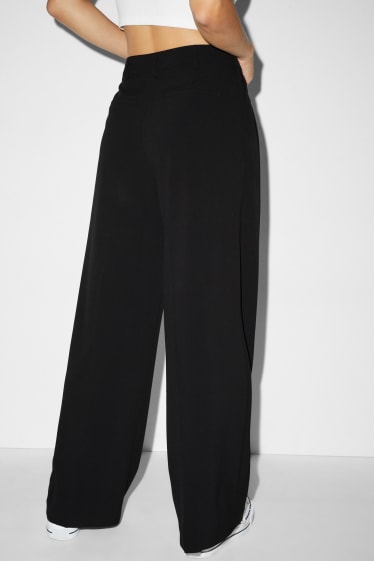 Kobiety - CLOCKHOUSE - spodnie materiałowe - średni stan - szerokie nogawki - czarny