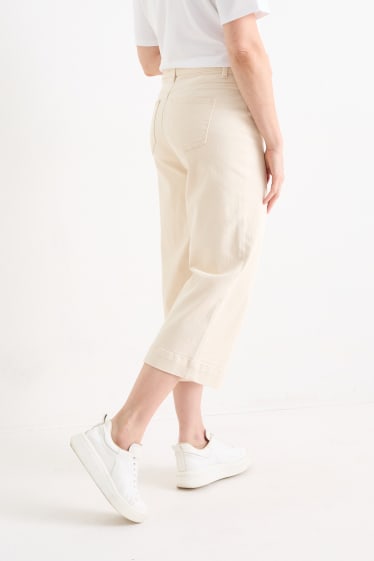 Kobiety - Spodnie materiałowe - średni stan - szerokie nogawki - jasny beż