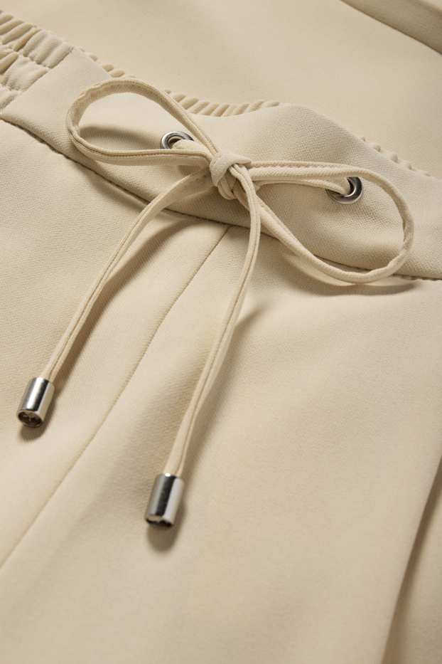 Dona - Pantalons de tela - mid waist - tapered fit - beix clar