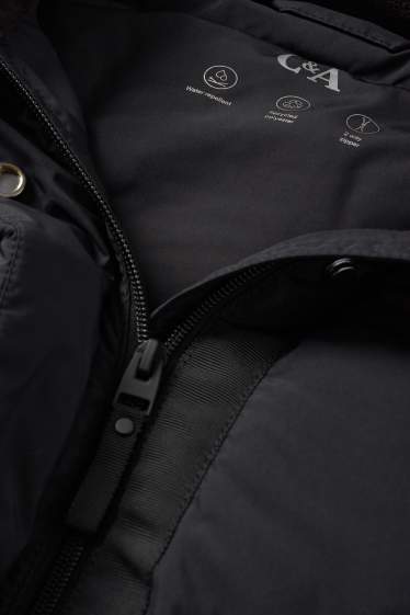 Dona - Jaqueta embuatada amb caputxa - resistent a l’aigua - negre