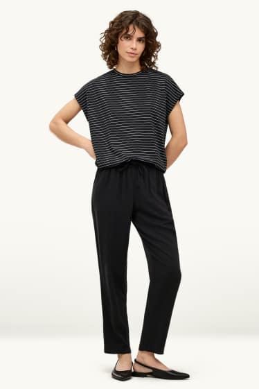 Dona - Pantalons de tela - mid waist - tapered fit - negre