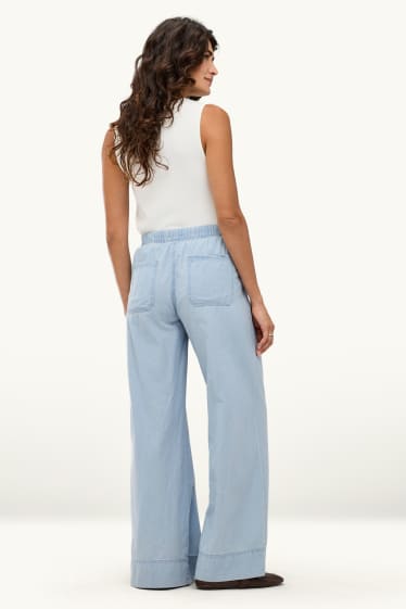 Dona - Pantalons de tela - mid waist - palazzo - blau clar