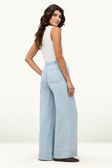 Dona - Pantalons de tela - mid waist - palazzo - blau clar