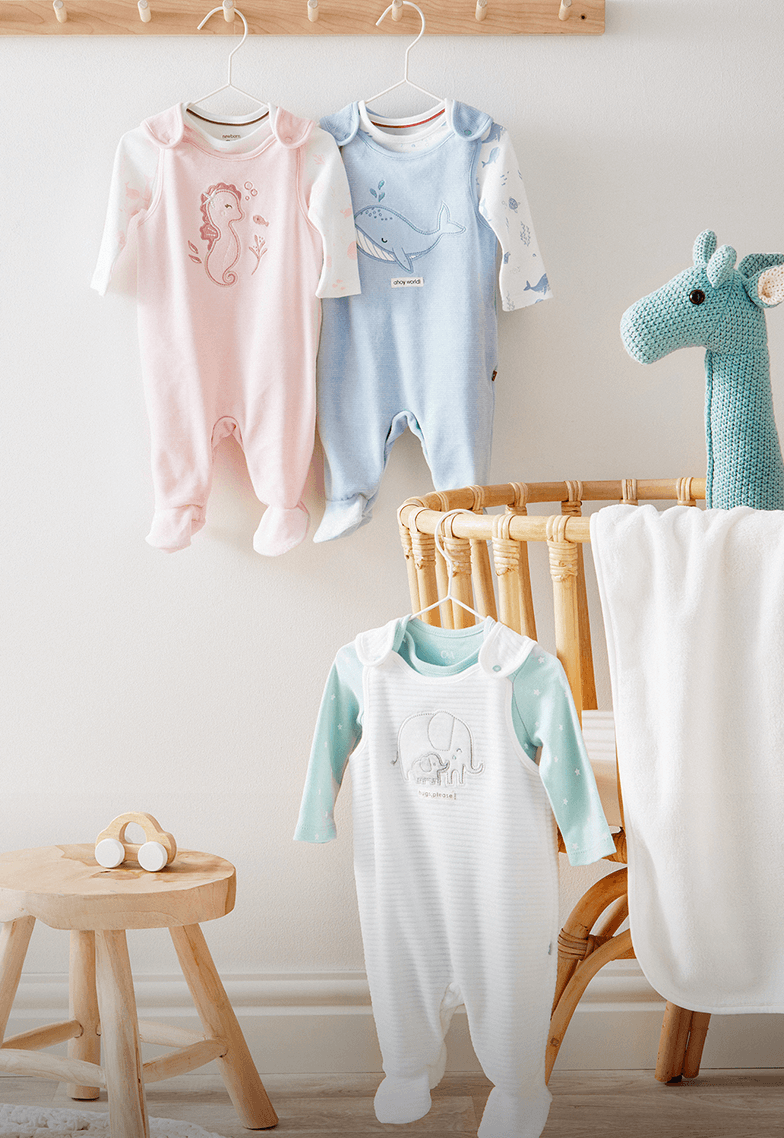 A child’s bedroom with gorgeous décor and a selection of cute baby outfits.