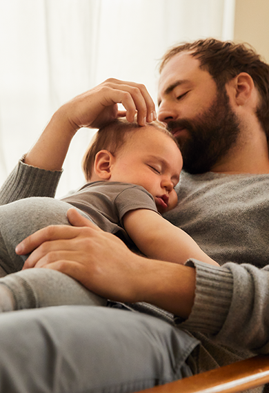 Un bébé dans un joli pyjama sourit à la caméra.