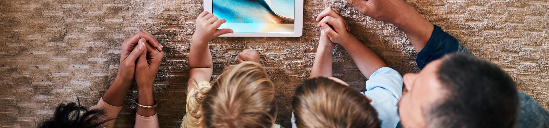 Media education: Family is looking at a tablet together.