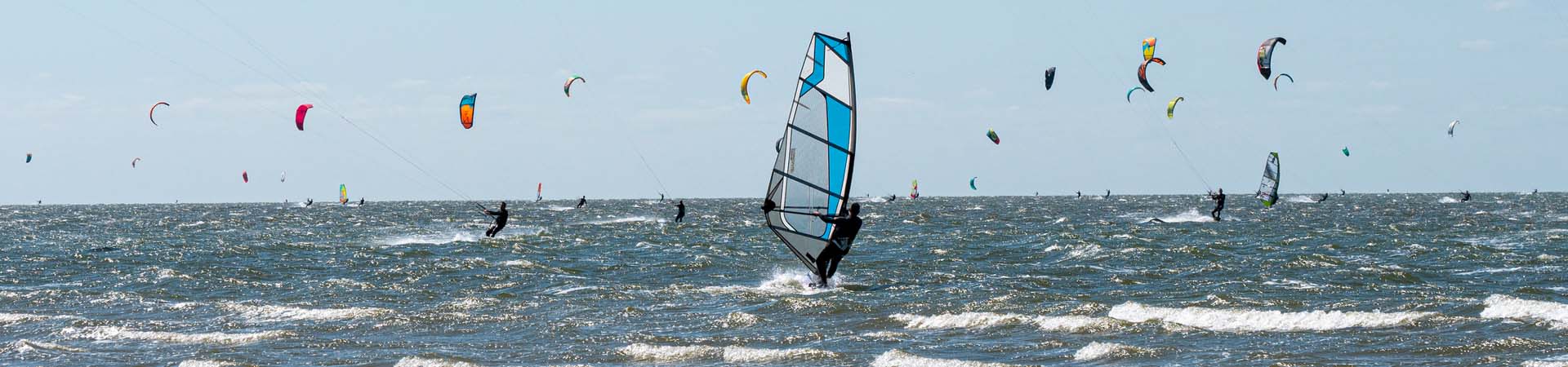 Watersport – Wind- en kitesurfers op de zee.
