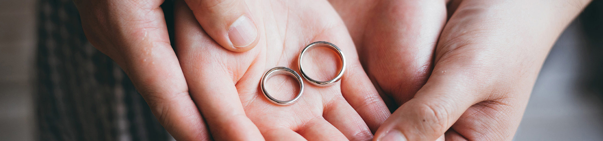 Wedding anniversaries by year: A married couple holding their wedding rings in their hands.