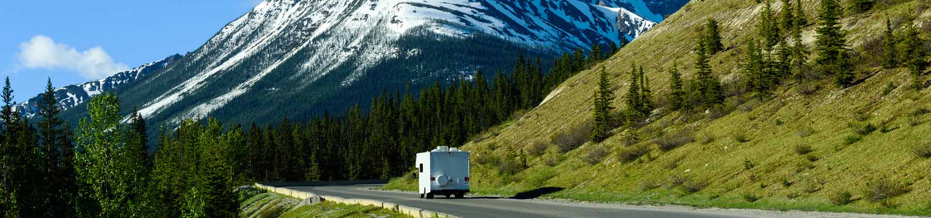 Guidare un camper – Un autocaravan attraversa un paesaggio di montagna.
