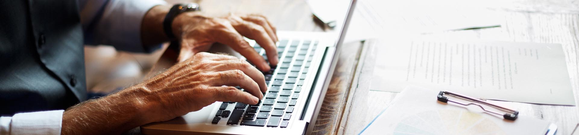Mann verschafft sich am Laptop einen Überblick über seine Finanzen.