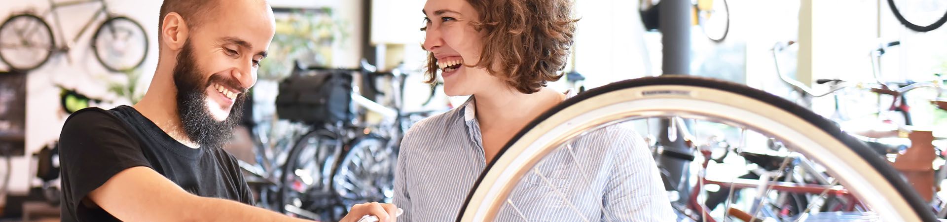Qué tipo de bicicleta comprar: una mujer se deja aconsejar en una tienda especializada.