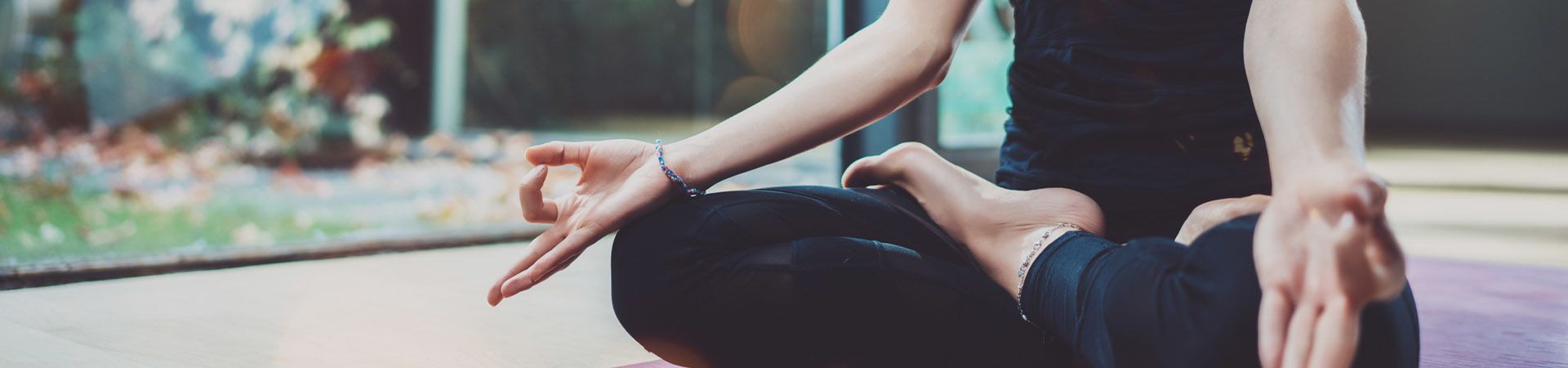 Hatha Yoga – woman sitting in a yoga pose.