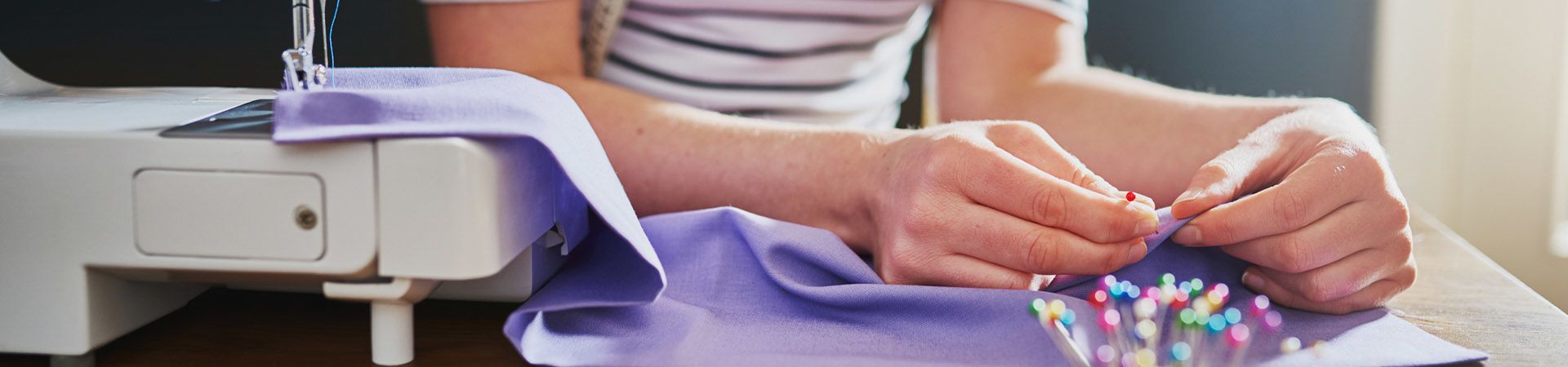 Upcycling ideeën uit stof: vrouw naait iets nieuws van oude kleren.