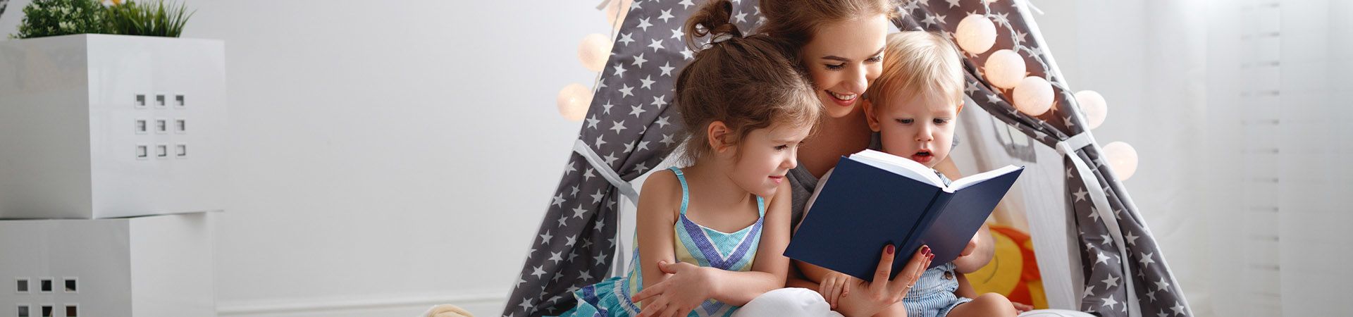 Moeder leest een boek voor aan haar twee kinderen.