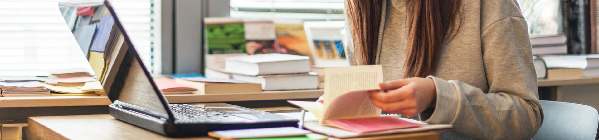 Une étudiante révise à la bibliothèque pour préparer ses examens.