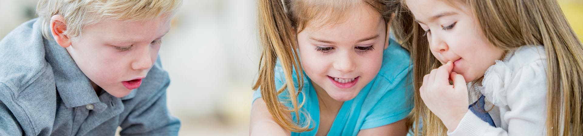 Leren lezen in de kleuterklas: kleuters kijken in een plaatjesboek.