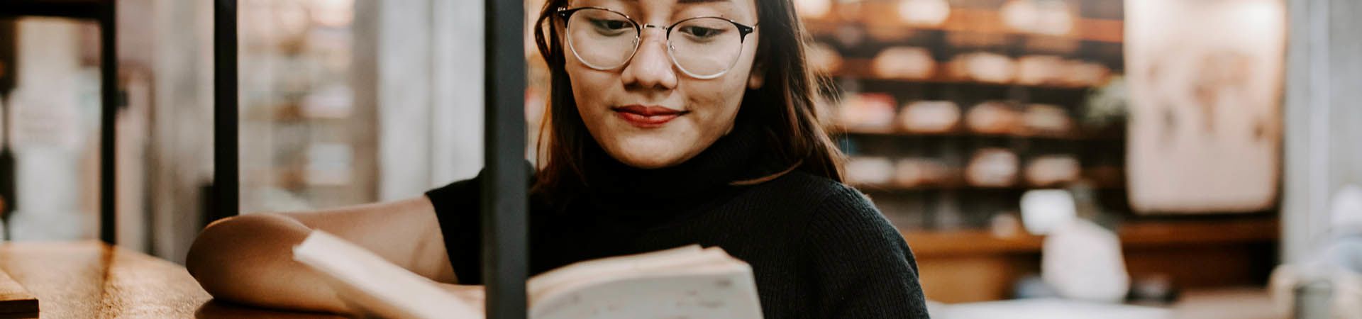 Leerling leest een boek over studieoriëntatie in de bibliotheek.