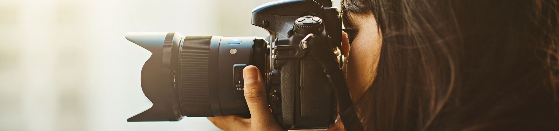 Macchina fotografica professionale per principianti: donna si esercita con la sua prima fotocamera.