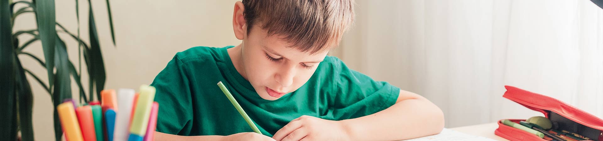 Scrivania per studiare e fare i compiti: bambino fa i compiti seduto alla scrivania.