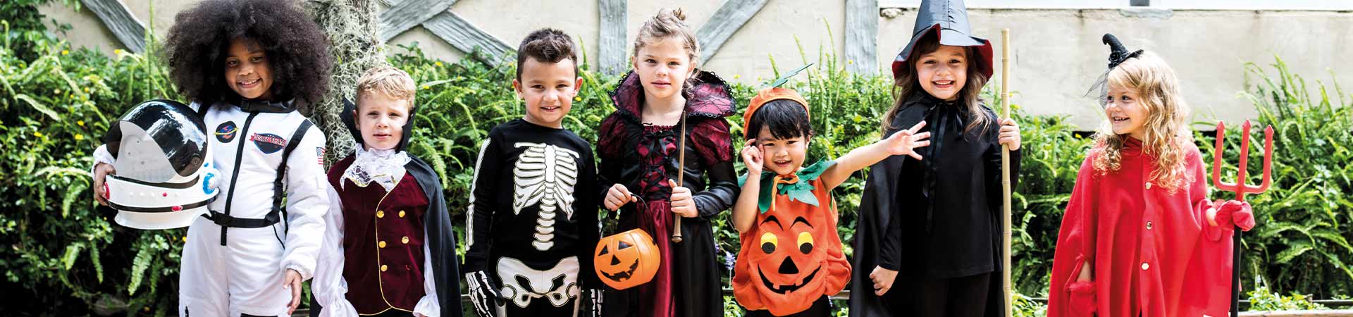 Making Halloween costumes for children: a group of children wearing different Halloween costumes.