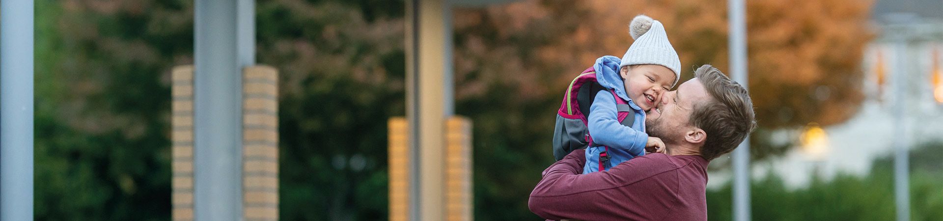 Kindergarten-Start – Vater verabschiedet sich vor der Kita von seinem Kind.