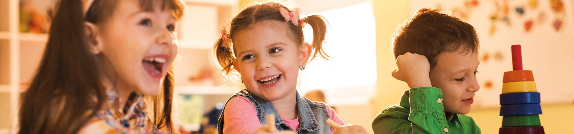 In de kinderopvang: kinderen lachen en tekenen samen.