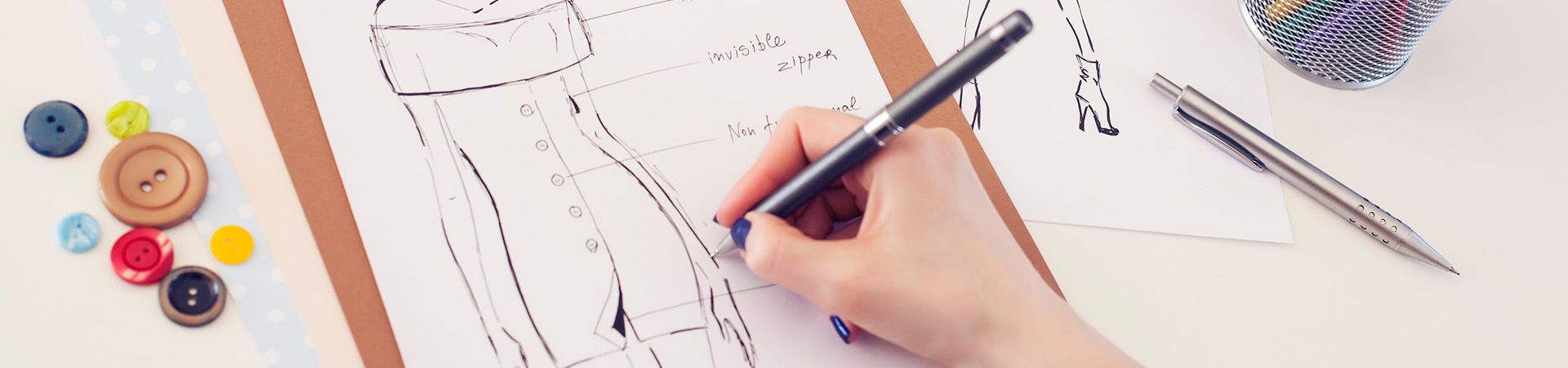 Fashion design studies: a designer sketches a dress.