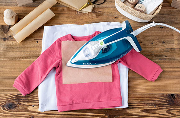 Mit Bügelfolie, Backpapier und Bügeleisen kannst du die Schrift auf den Pullover bringen. Mit Bügelfolie, Backpapier und Bügeleisen kannst du die Schrift auf den Pullover bringen.