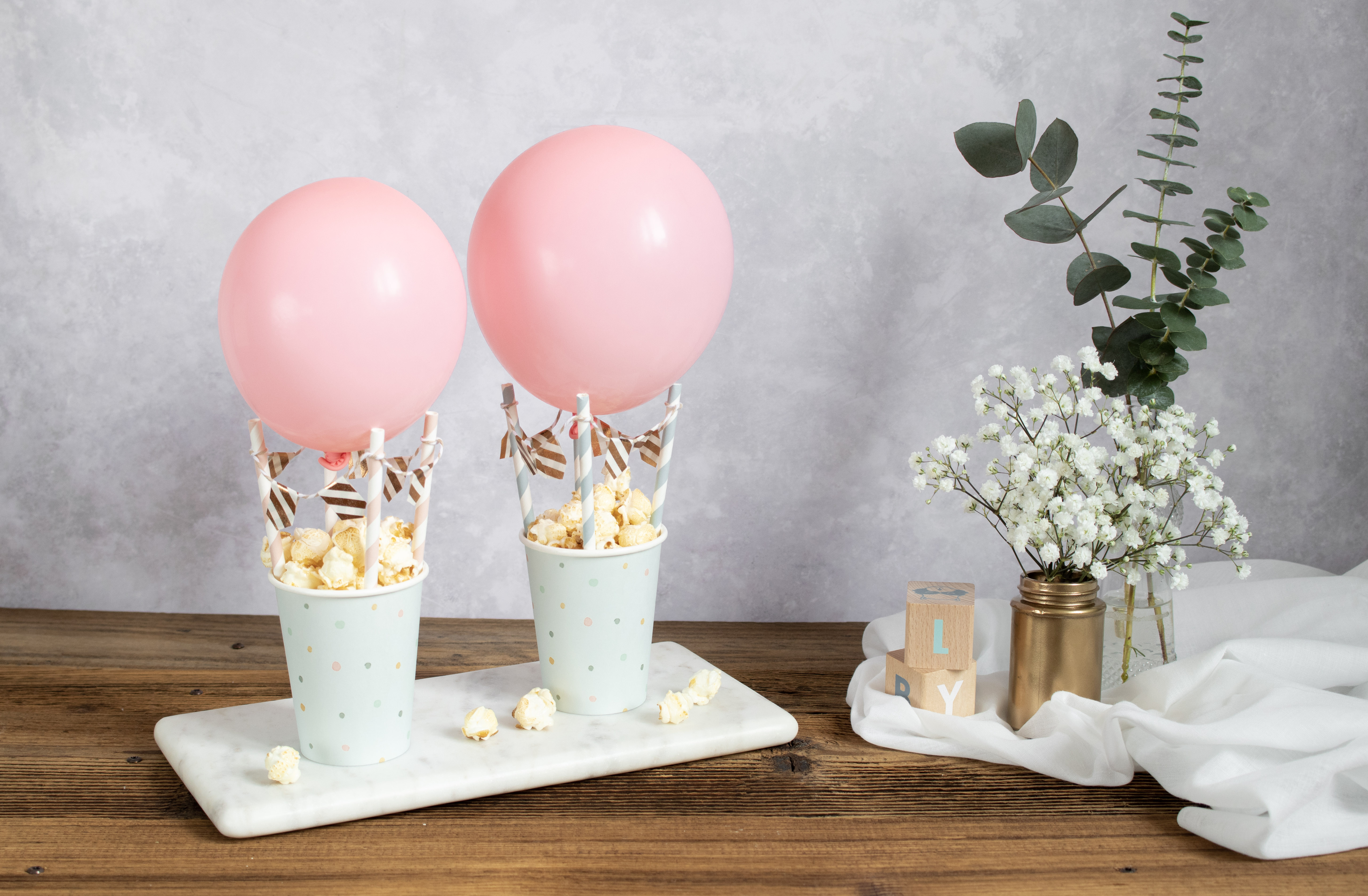 DIY hot air balloons filled with popcorn used for decorating for a baby shower.