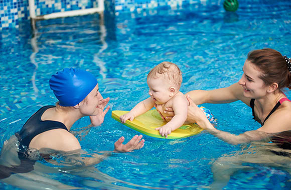Mutter und Kind genießen die Nähe beim Babyschwimmen