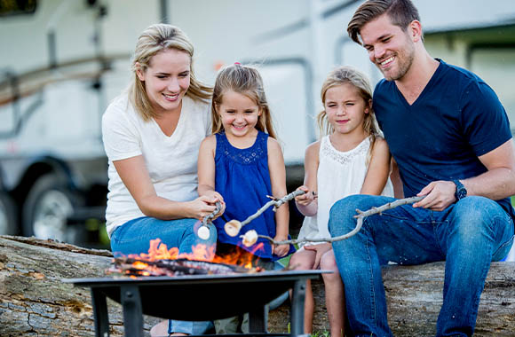 Camping mit Kindern – Familie röstet zusammen Marshmallows. Camping mit Kindern – Familie röstet zusammen Marshmallows.